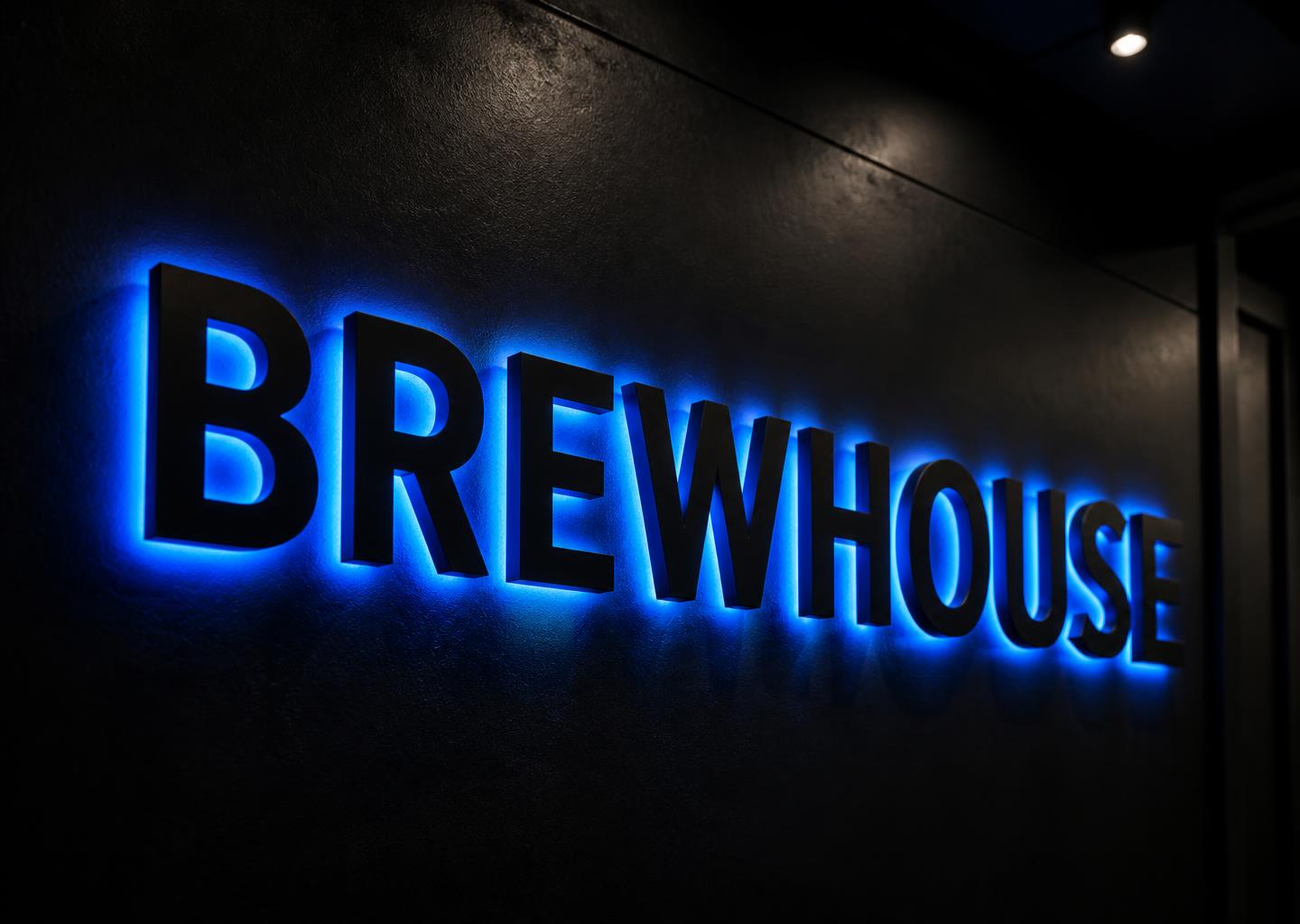BREWHOUSE blue backlit channel letters on a black wall